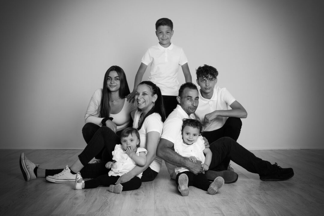 Séance photo famille assise dans un studio professionnel