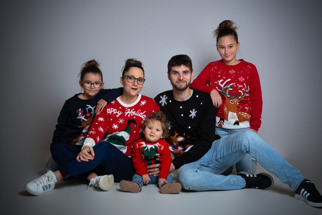 Photo de famille réunie autour du plus jeune enfant en studio